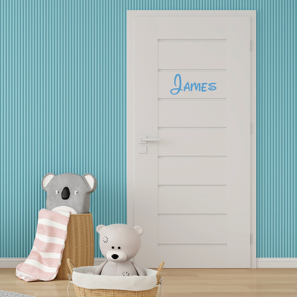 Children's room with a door featuring the name 'James', toys, and striped wallpaper.